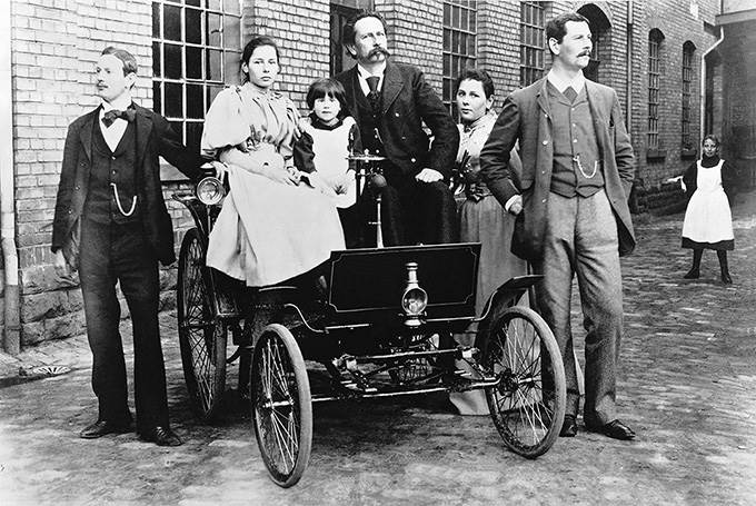 Carl Benz (im dunklen Anzug) mit seiner Familie auf einem Benz Comfortable mit 2,6 kW (3,5 PS) starkem Motor. 

Carl Benz (in the dark suit) with his family in a Benz Comfortable rated to 2.6 kW (3.5 hp).